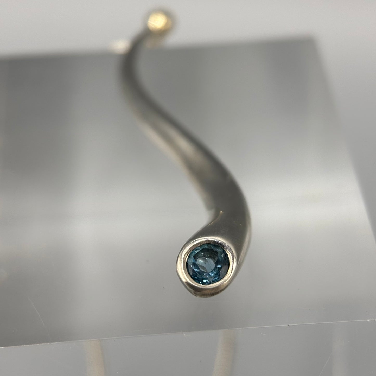 Paul Finch - Pendant: Curving solid silver with blue topaz & solid 18ct Yellow Gold bead